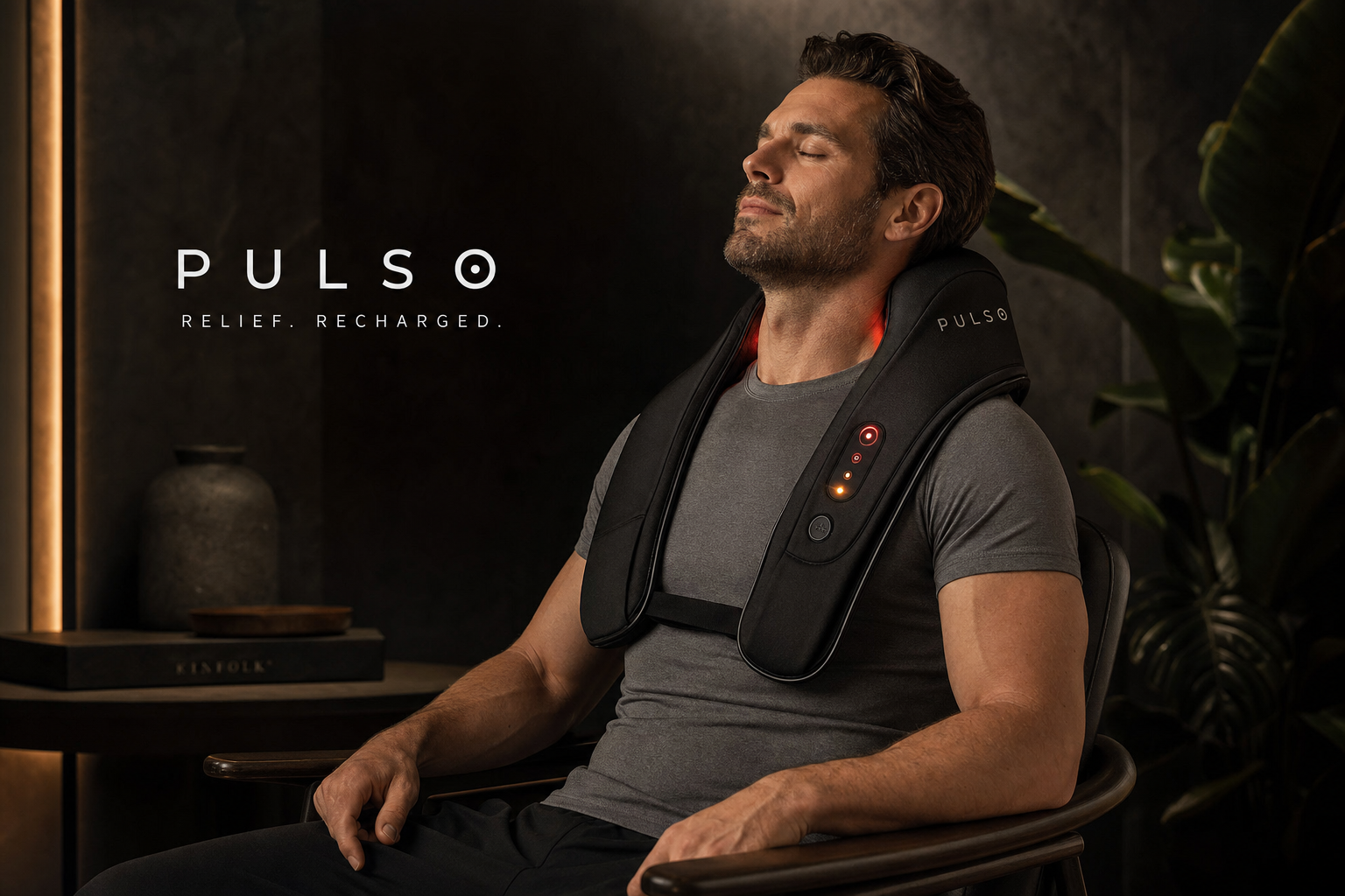 Man relieving neck and shoulder tension with PULSO Heated Shoulder Wrap